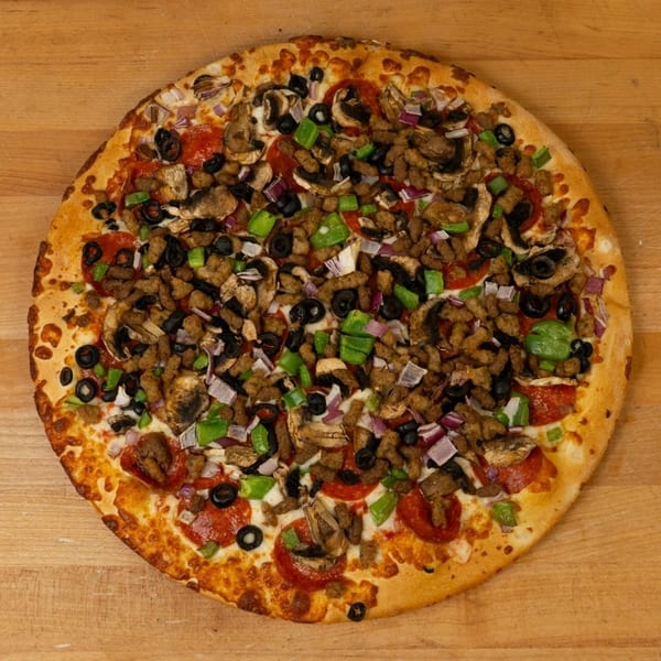 A whole pizza topped with pepperoni, sausage, mushrooms, black olives, green peppers, and red onions.