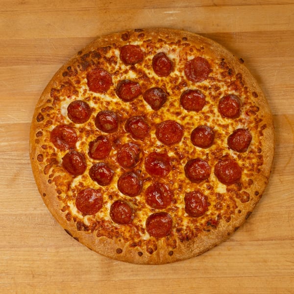 A whole pepperoni pizza with a golden crust and melted cheese on a wooden surface.